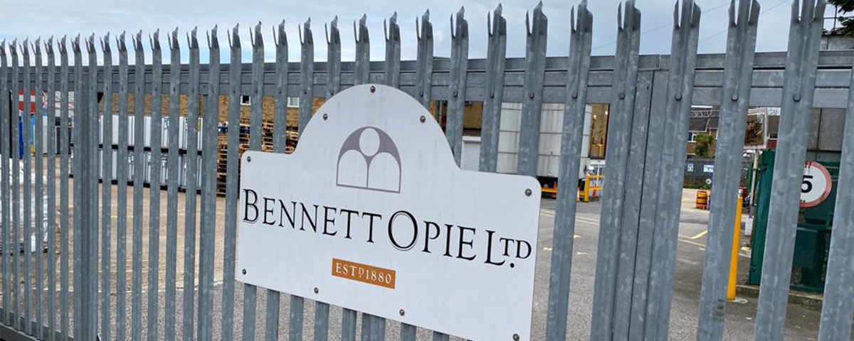 A gray metal gate with a Bennett Opie Ltd sign